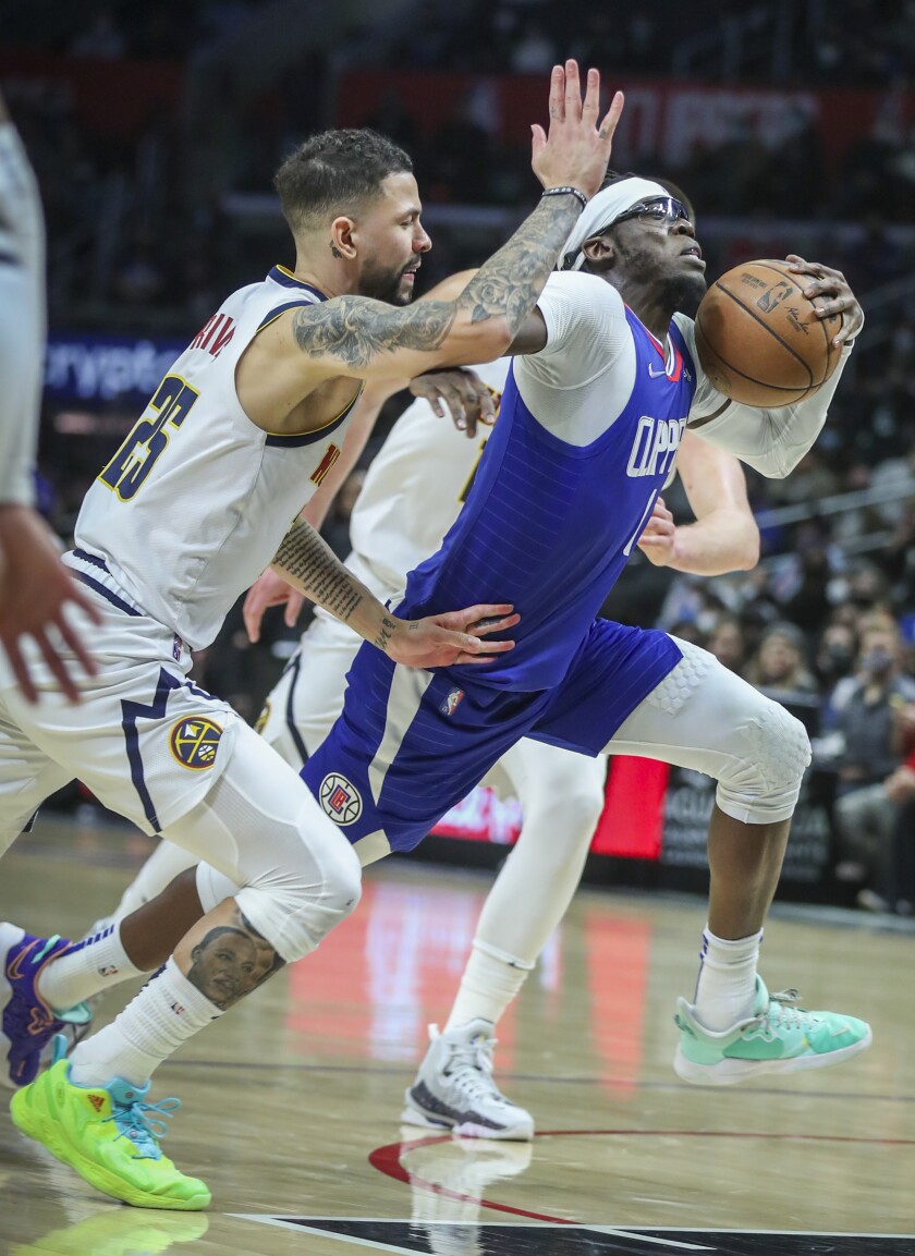 Denver Nuggets guard Austin Rivers battles Clippers guard Reggie Jackson as he drives to the hoop.