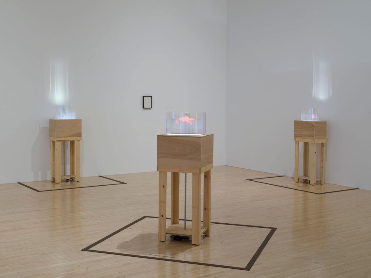 three projectors on wooden stands in an art installation 