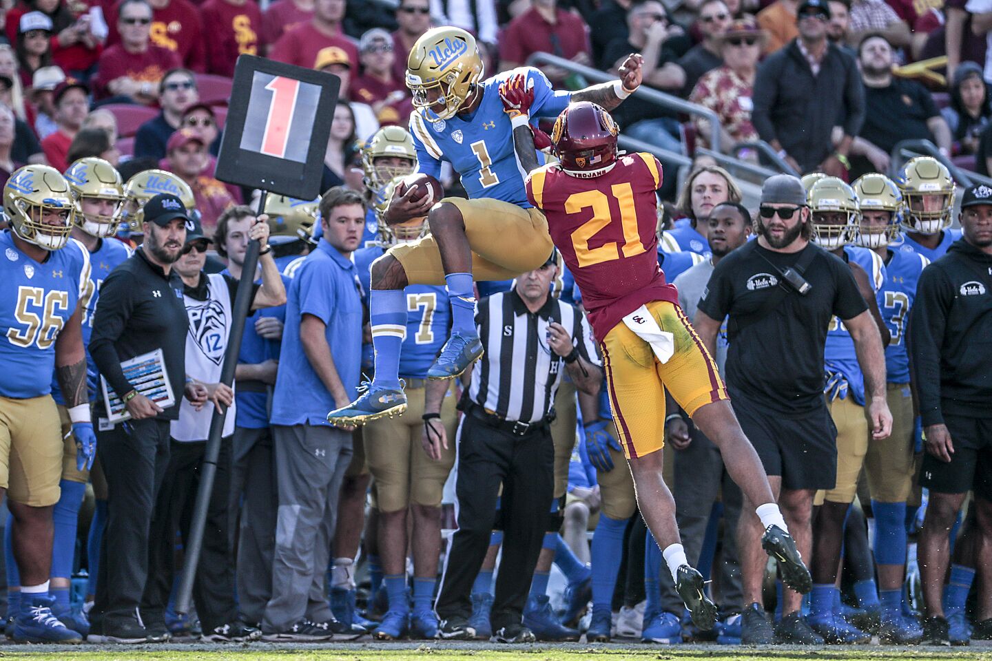 UCLA quarterback Dorian Thompson-Robinson (1) is shoved out of bounds by USC cornerback Olaijah Griffin (2) during first half action at the Coliseum on Saturday.