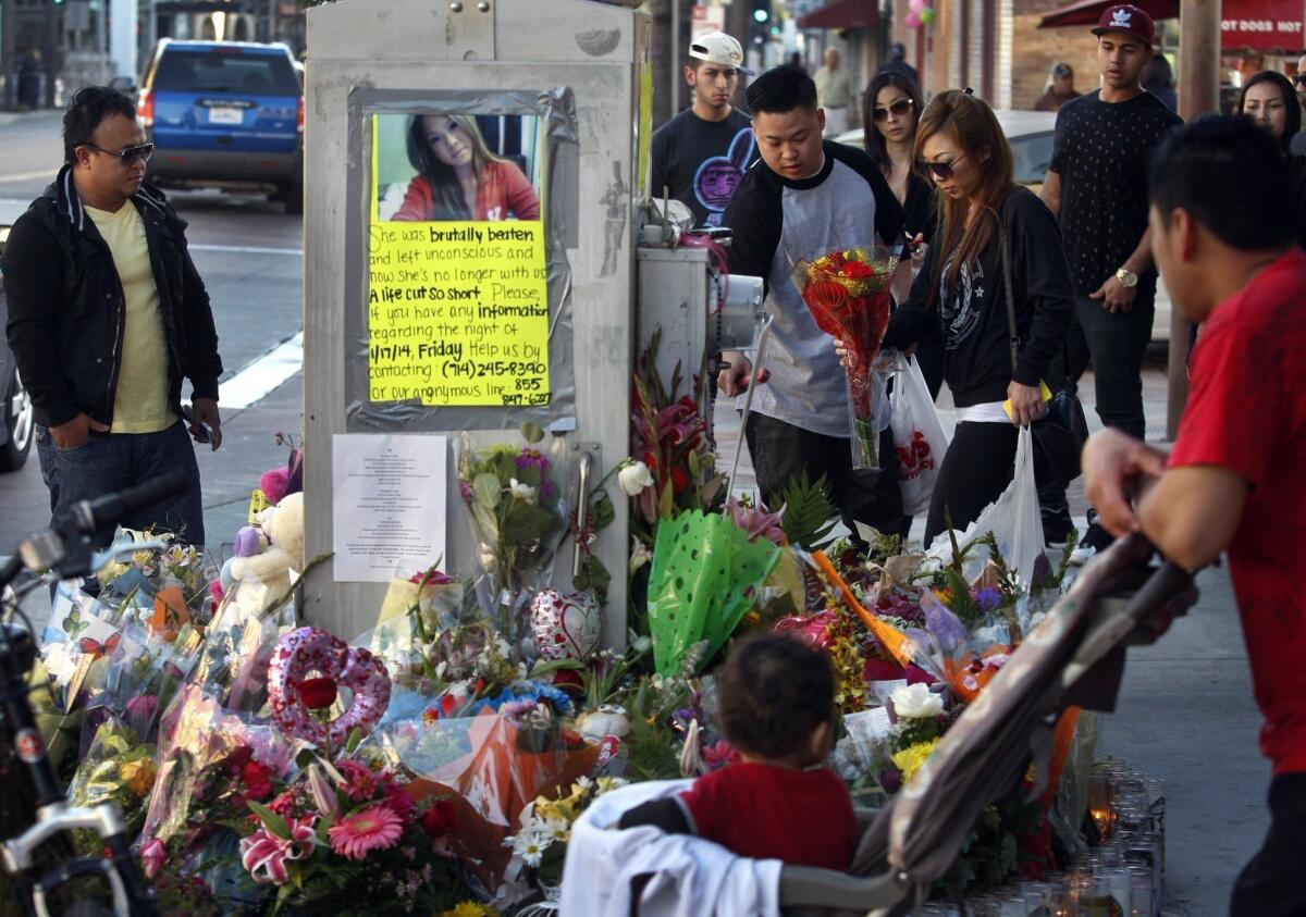 Spectators look over a memorial for Kim Pham, who was beaten to death outside a nightclub in Santa Ana last month.