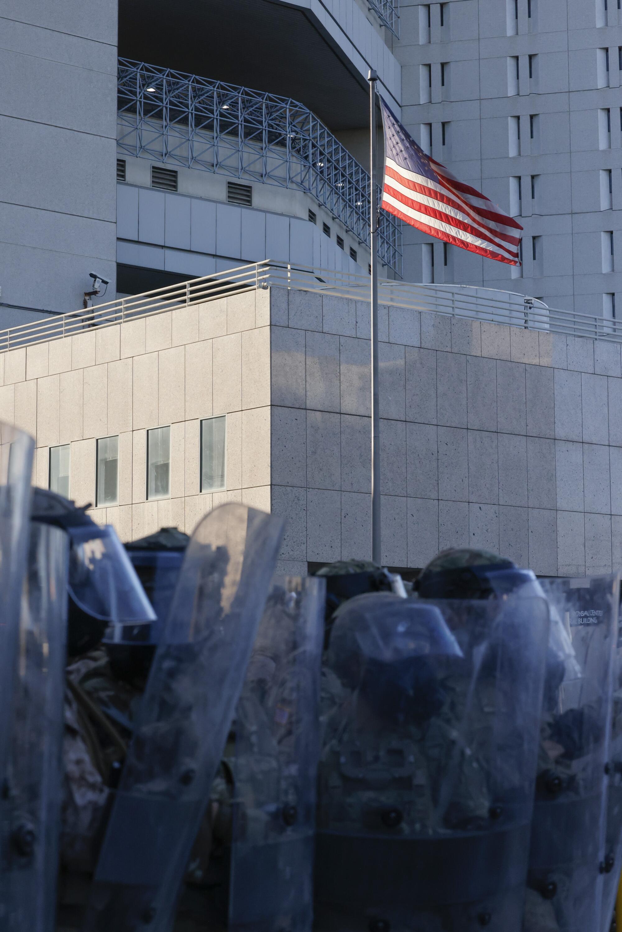 The U.S. flag flies behind Marines standing guard.