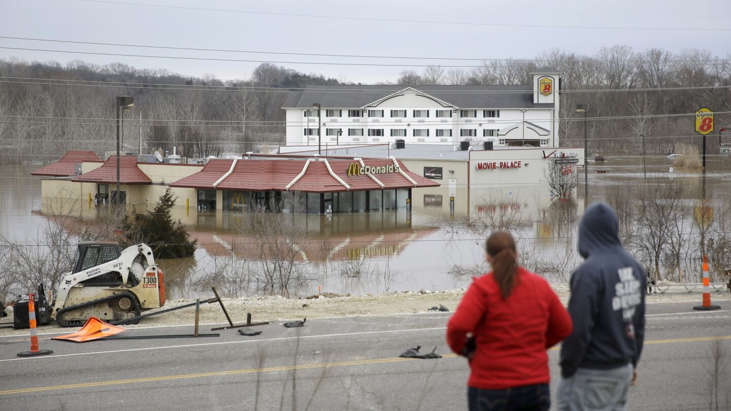 People stand on a hill to get a better look at floodwater from the Bourbeuse River Tuesday, Dec. 29, 2015, in Union, Mo. Flooding across Missouri has forced the closure of hundreds of roads and threatened homes.