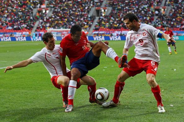 Stephan Lichtsteiner (L) and Alexander Frei (R) of Switzerland tackle Jean Beausejour of Chile during the 2010 FIFA World Cup South Africa Group H match between Chile and Switzerland at Nelson Mandela Bay Stadium on June 21, 2010 in Port Elizabeth, South Africa.