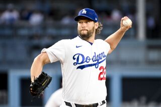 Dodgers starting pitcher Clayton Kershaw scrunches his face and delivers a pitch from the mound