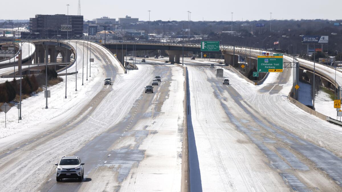 A snow-covered freeway with very few vehicles