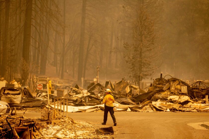A firefighter surveys a destroyed downtown during the Dixie fire in Greenville, California on August 5, 2021. - The largest wildfire in California has razed a small town, warping street lights and destroying historic buildings hours after residents were ordered to flee. Greenville, an Indian Valley settlement of a few hundred people dating back to the mid-1800s Gold Rush, was engulfed by flames as winds whipped the inferno towards the community, turning the sky orange. (Photo by JOSH EDELSON / AFP) (Photo by JOSH EDELSON/AFP via Getty Images)
