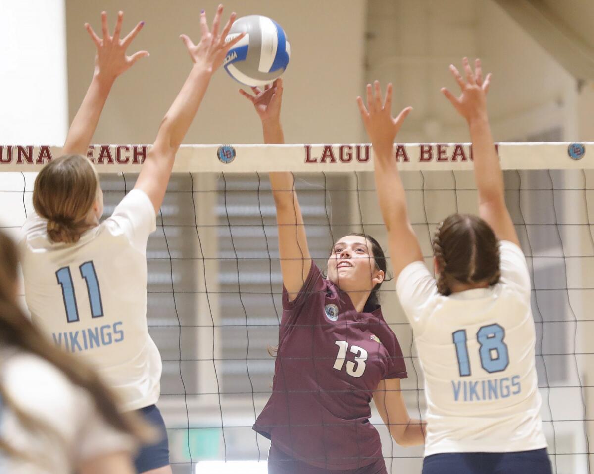 Meg Gardner (13) of Laguna Beach puts a kill past the block of Marina's Lyndsey Wessel on Tuesday.