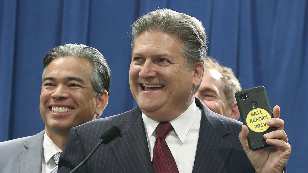 State Sen. Bob Hertzberg (D-Van Nuys), right, and Assemblyman Rob Bonta (D-Alameda) celebrate during a news conference after the bill they co-authored to end money bail was approved.