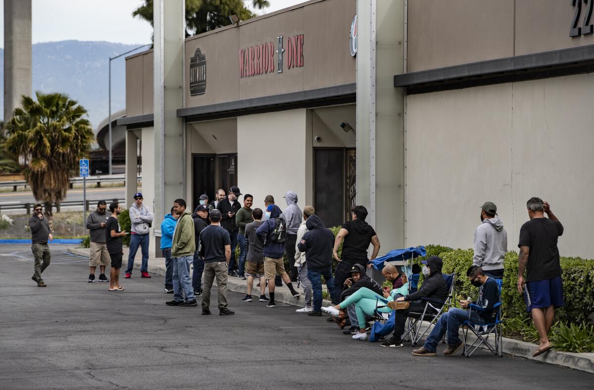 Customers wait in line Tuesday to buy guns at Warrior One Guns and Ammo in Riverside.