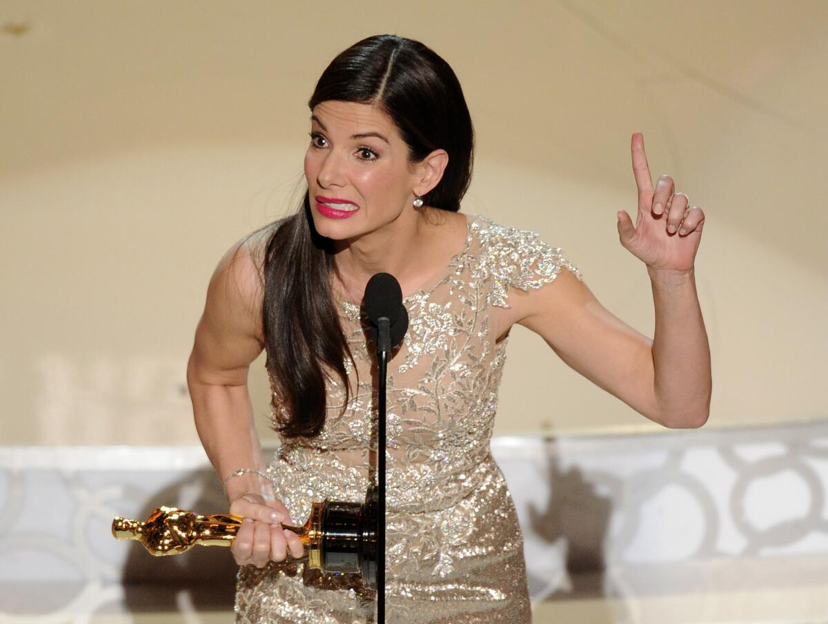 A woman holds an Oscar while make a point