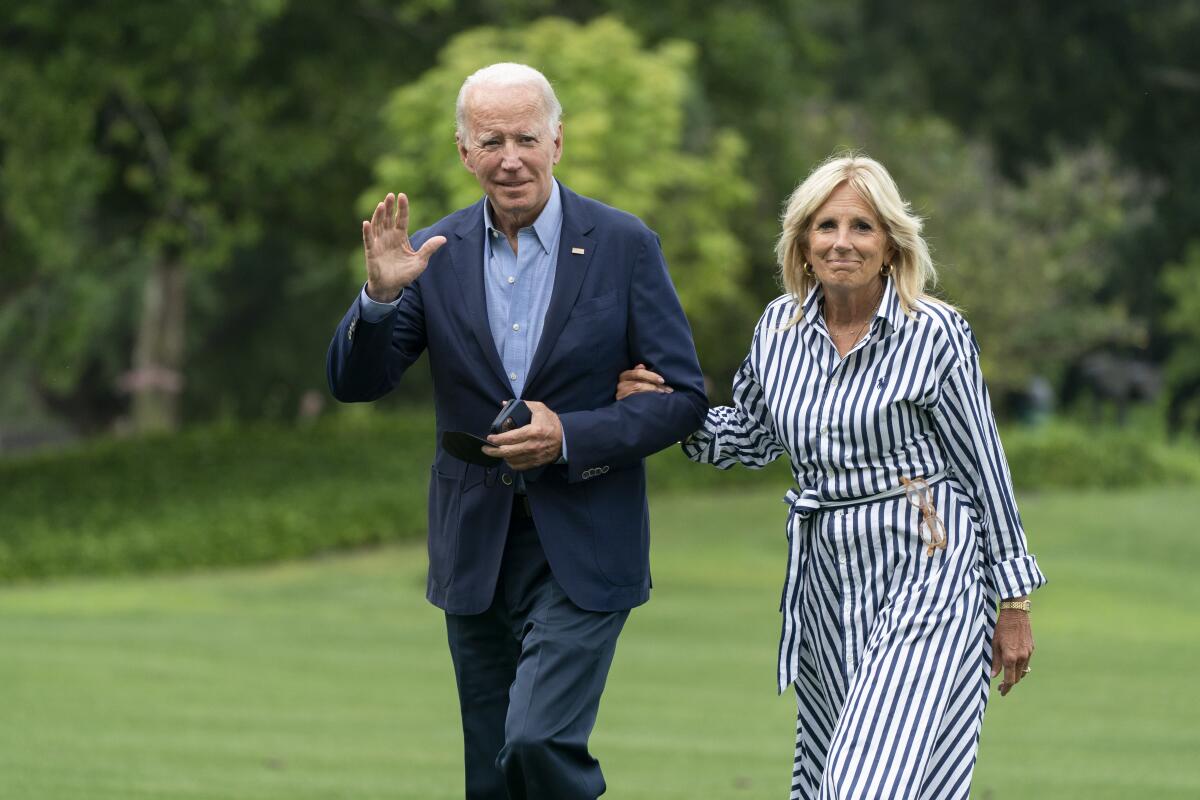 President Joe Biden with first lady Jill Biden waves as they walk on the South Lawn of the White House 