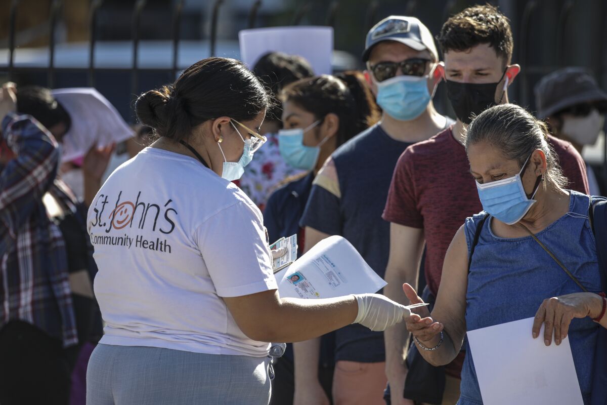 People wait in line to get vaccinated against monkeypox at a St. John's Community Health site in Los Angeles.