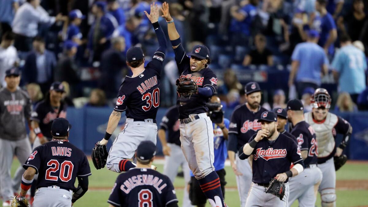 Jugadores de los Indians de Cleveland celebran su tercera victoria en la serie ante los Blue Jays de Toronto que les pone a un juego de su pase a la final del beisbol estadounidense.