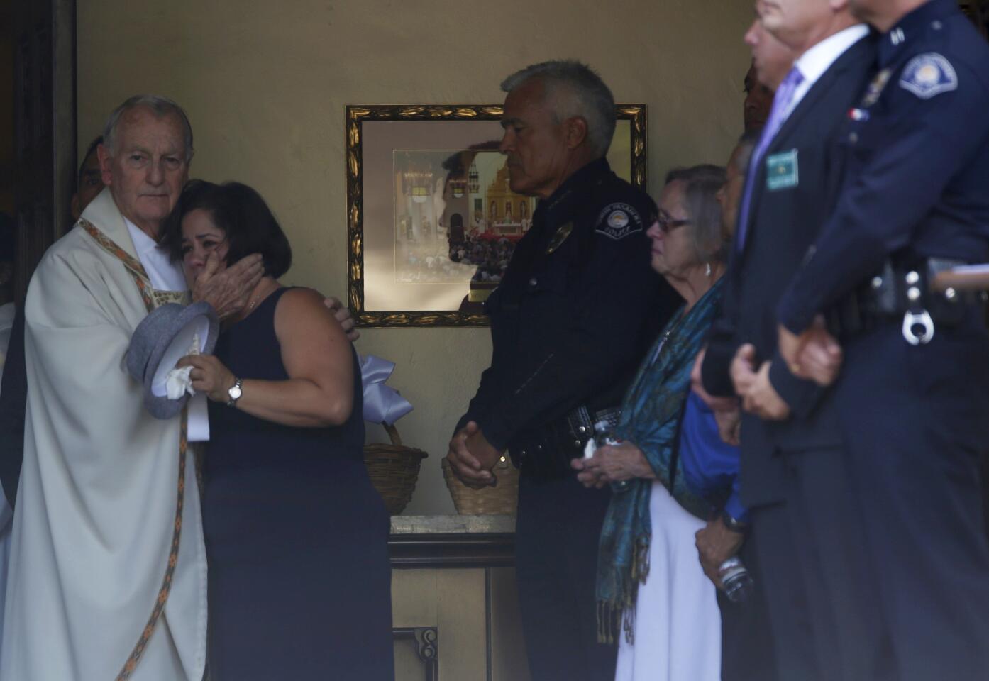 Monsignor Clement J. Connolly left, comforts Ana Estevez as she watches her son's small, white casket being carried into Holy Family Catholic Church in South Pasadena.