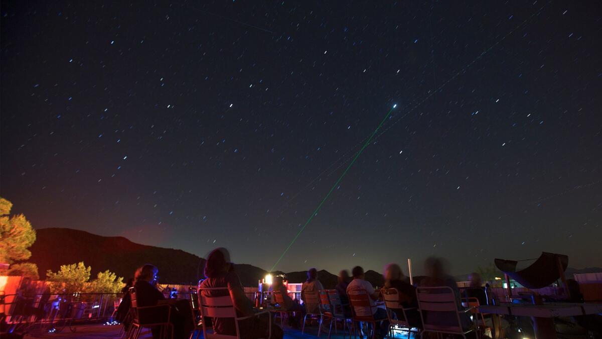 A long camera exposure captures a laser beam pointing to Europa, Jupiter's moon, at the Astronomy Arts Theater in Joshua Tree, Calif.