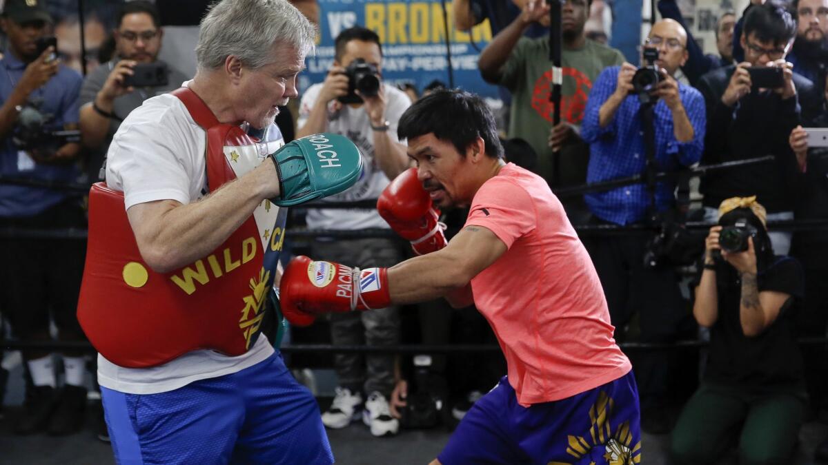 Manny Pacquiao, right, works out with trainer Freddie Roach at a boxing club in Los Angeles, Wednesday.