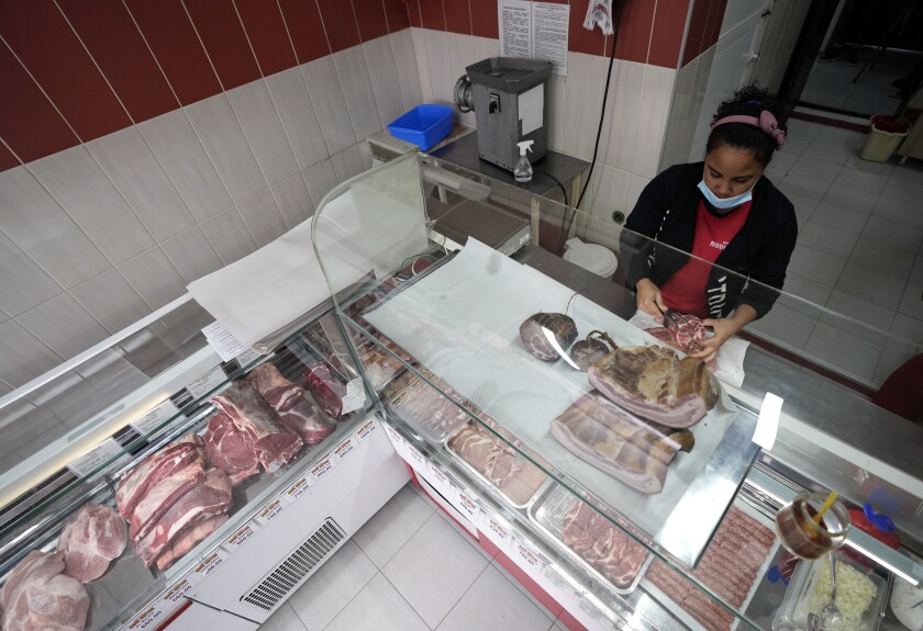 Belquis Gonzales works at a butcher shop in a small Serbian town of Lajkovac, Tuesday, Nov. 30, 2021. While most Cuban citizens who wish to emigrate go to the United States or to Spanish-speaking nations, Gonzales and her husband chose Serbia, a rare country in Europe where they didn't need visas. (AP Photo/Darko Vojinovic)