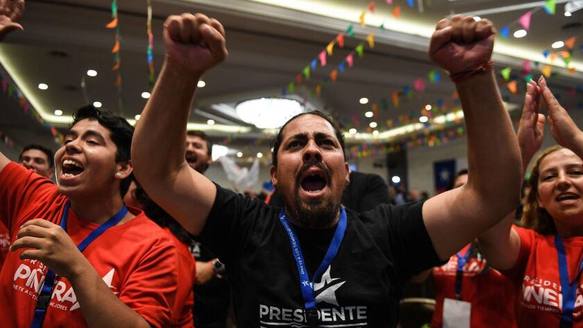 Supporters of Chilean presidential candidate Sebastian Piñera celebrate the unofficial exit poll results at the party's headquarters in Santiago on Dec. 17, 2017.