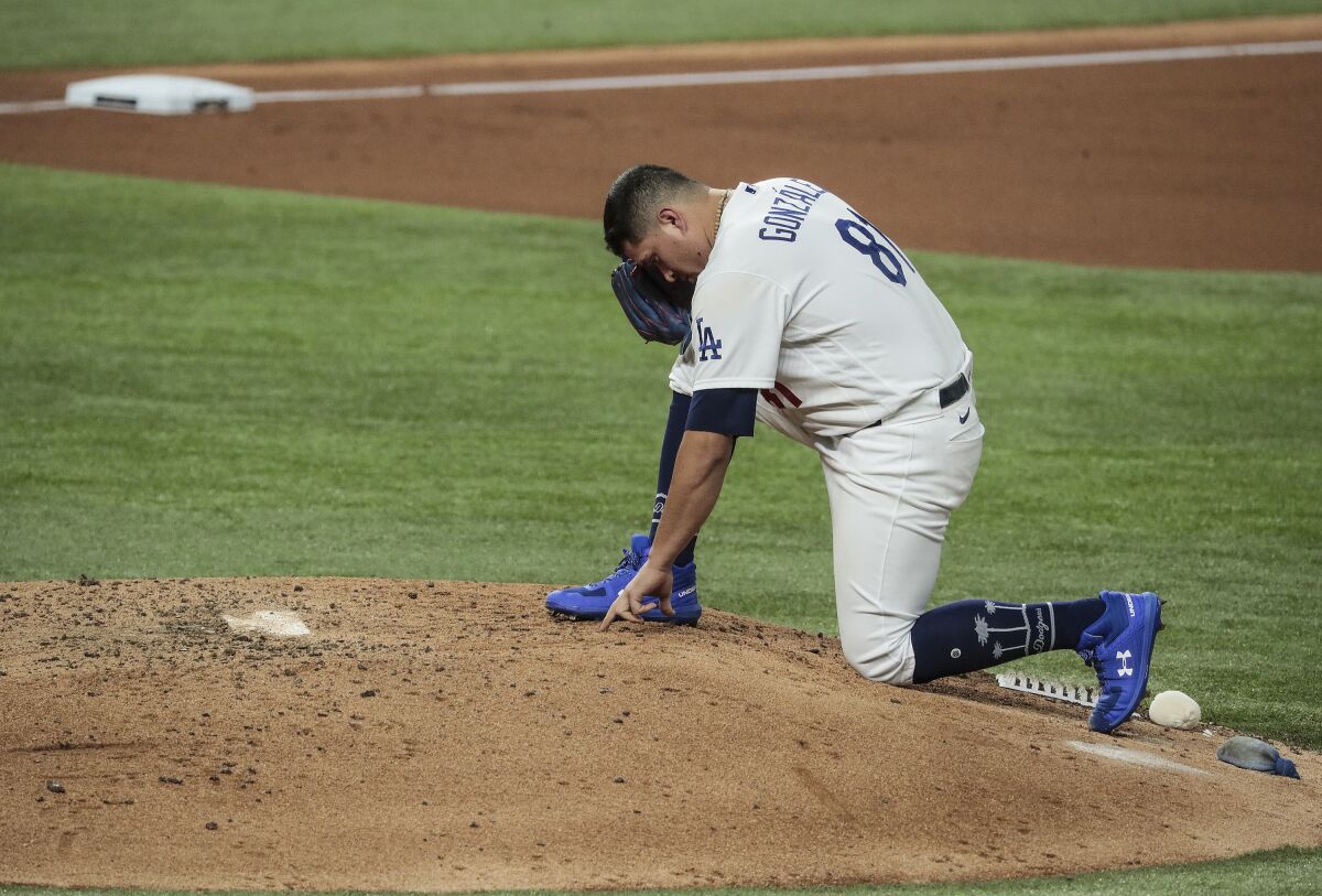 Dodgers reliever Victor González writes in the dirt before pitching in the fifth inning of Game 6.