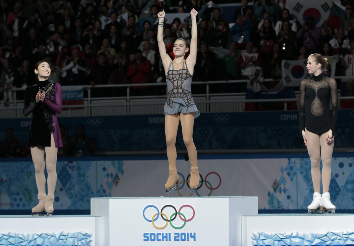 Adelina Sotnikova of Russia, center, Yuna Kim of South Korea, left, and Carolina Kostner of Italy stand on the podium during the flower ceremony for the women's free skate figure skating final during the 2014 Winter Olympics in Sochi, Russia. Sotnikova placed first, followed by Kim and Kostner, but her win is proving to be controversial.