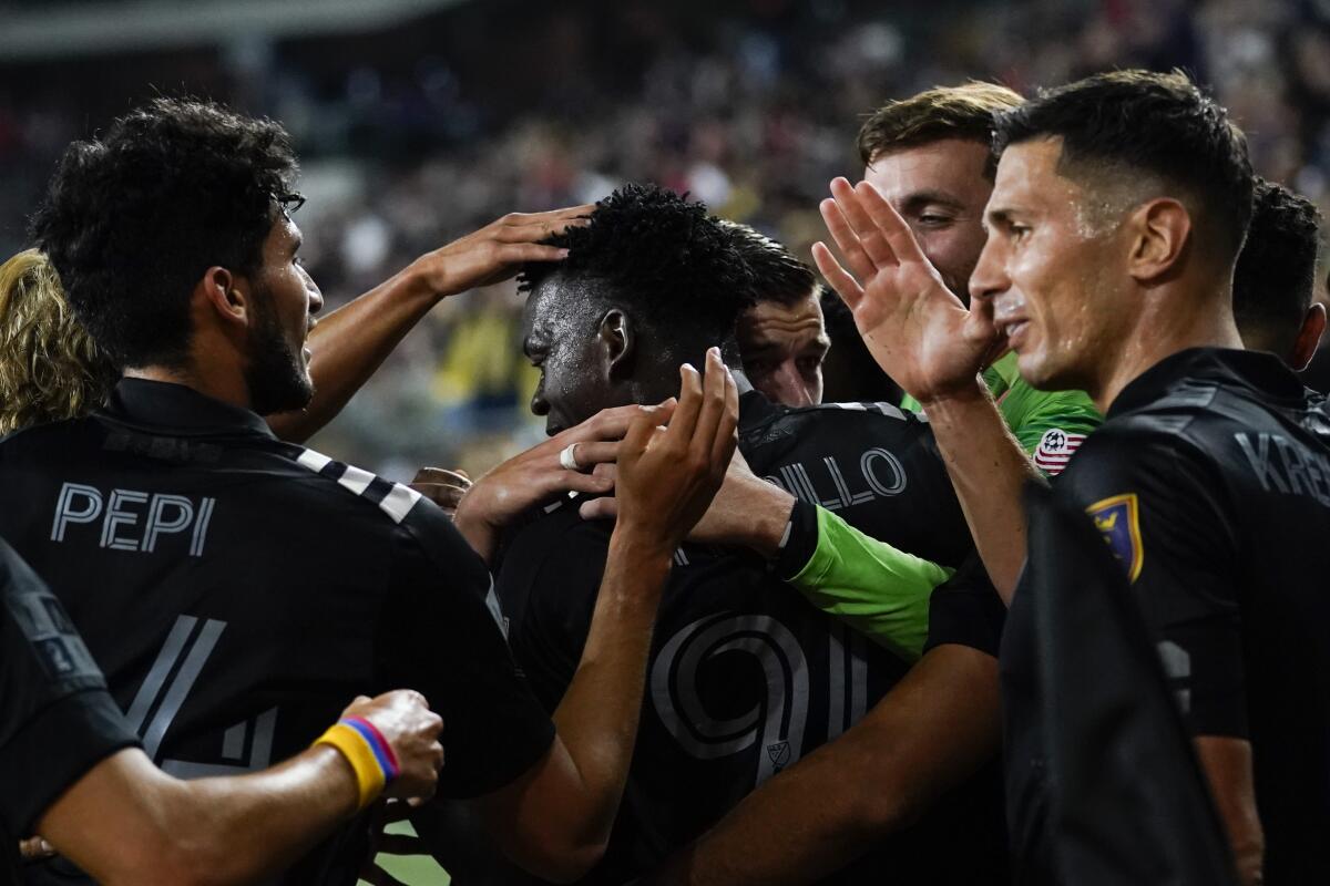 MLS All-Star players celebrate with Los Angeles FC defender Jesus David Murillo, center, after scored a goal during the second half of the MLS All-Star soccer match against the Liga MX All-Stars Wednesday, Aug. 25, 2021, in Los Angeles. (AP Photo/Ashley Landis)
