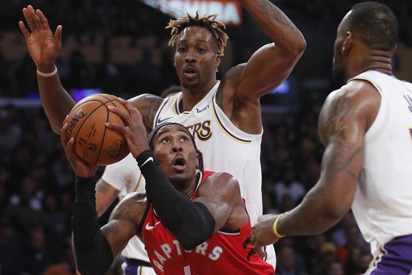 LOS ANGELES, CALIF. - NOV. 10, 2019. Raptors forward Rondae Hollis-Jefferson goes up for a basket against Lakers Dwight Howard, left, and LeBron James in the fourth quarter at Staples Center in Los Angeles on Sunday night, Nov. 10, 2019. (Luis Sinco/Los Angeles Times)