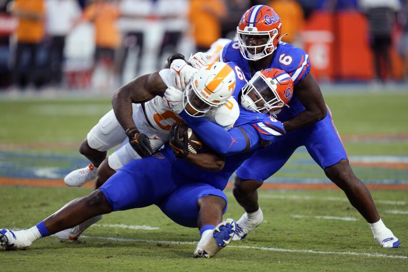 Florida defensive lineman Cam Jackson, center, stops Tennessee running back Jaylen Wright (0) for no gain, as linebacker Shemar James (6) comes in to help during the first half of an NCAA college football game, Saturday, Sept. 16, 2023, in Gainesville, Fla. (AP Photo/John Raoux)