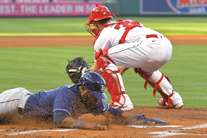 ADDS THAT MARGOT SCORES ON A FIELDING ERROR AND A SINGLE - Tampa Bay Rays' Manuel Margot, left, scores after a single by Brandon Lowe and a fielding error by Los Angeles Angels second baseman David Fletcher as catcher Max Stassi takes a late throw during the first inning of a baseball game Tuesday, May 4, 2021, in Anaheim, Calif. (AP Photo/Mark J. Terrill)