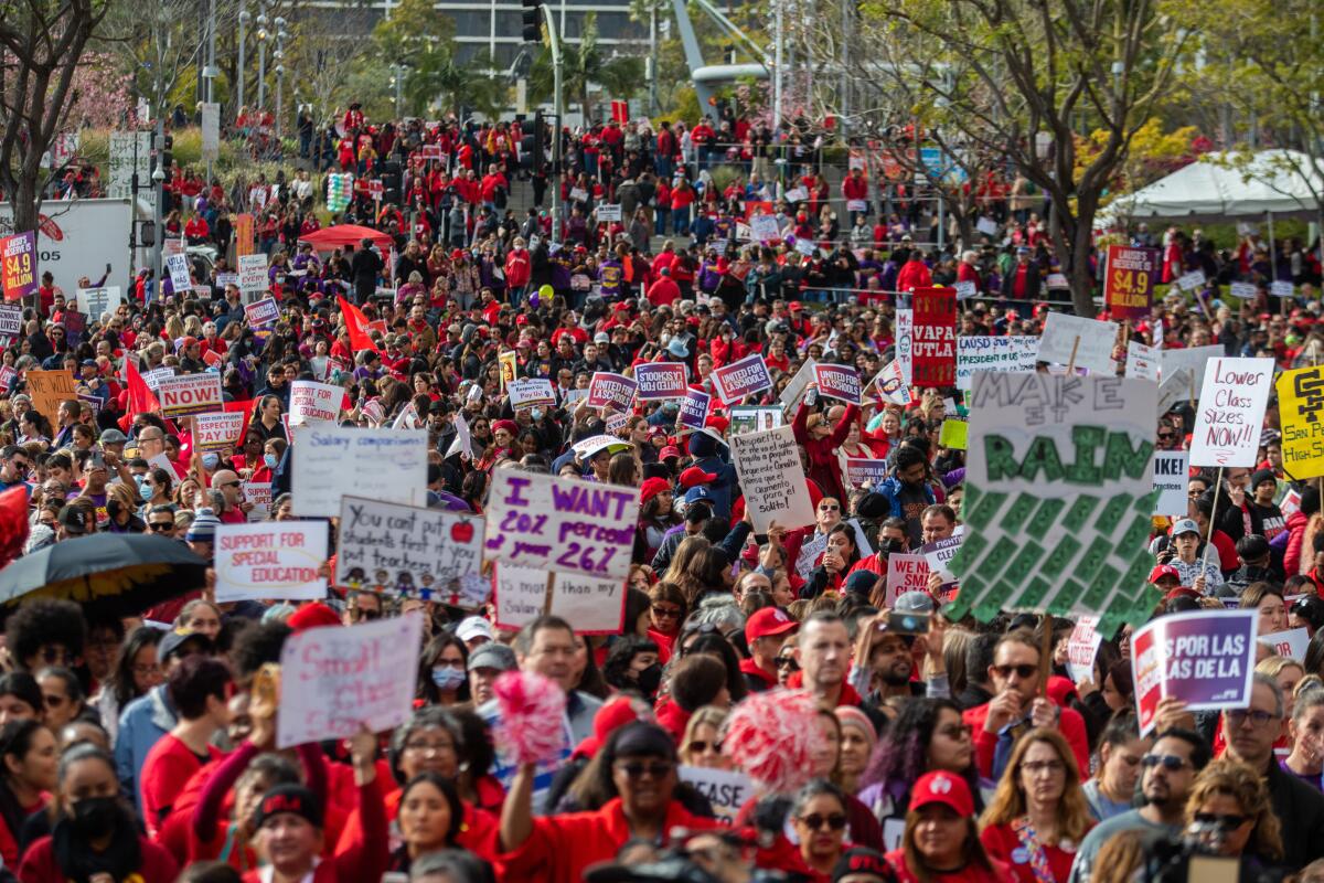  A large crowd carrying signs rally in Grand Park.