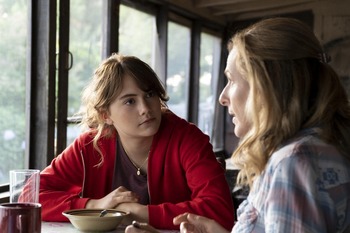 A mother and daughters sit at the breakfast table.