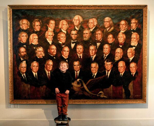 Presidential enthusiast Arden Hayes, 5, poses in front of a painting titled "A Presidential Pantheon," by Victor Lee, at the Nixon library in Yorba Linda.