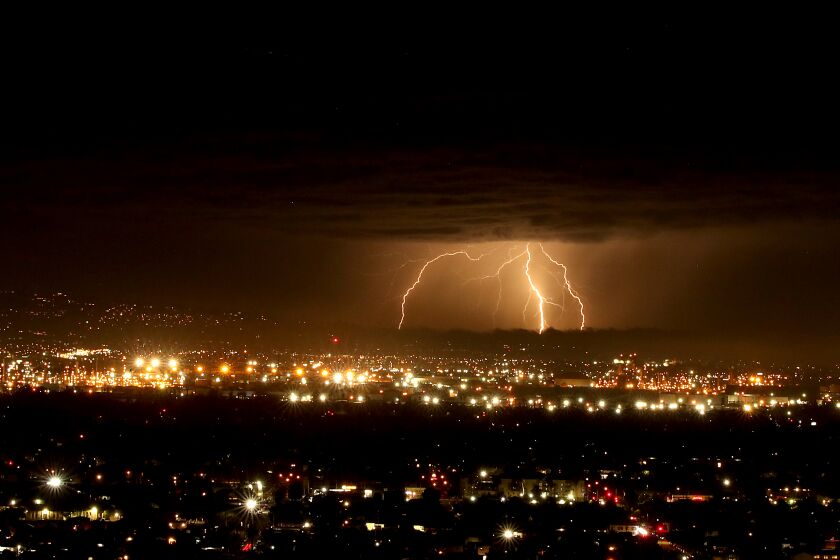 SIGNAL HILL, CALIF. - OCT. 4, 2021. Lightning flares from the clouds above the South Bay as a storm moves across the Los Angeles Basin on Monday, Oct. 4, 2021. (Luis Sinco / Los Angeles Times)