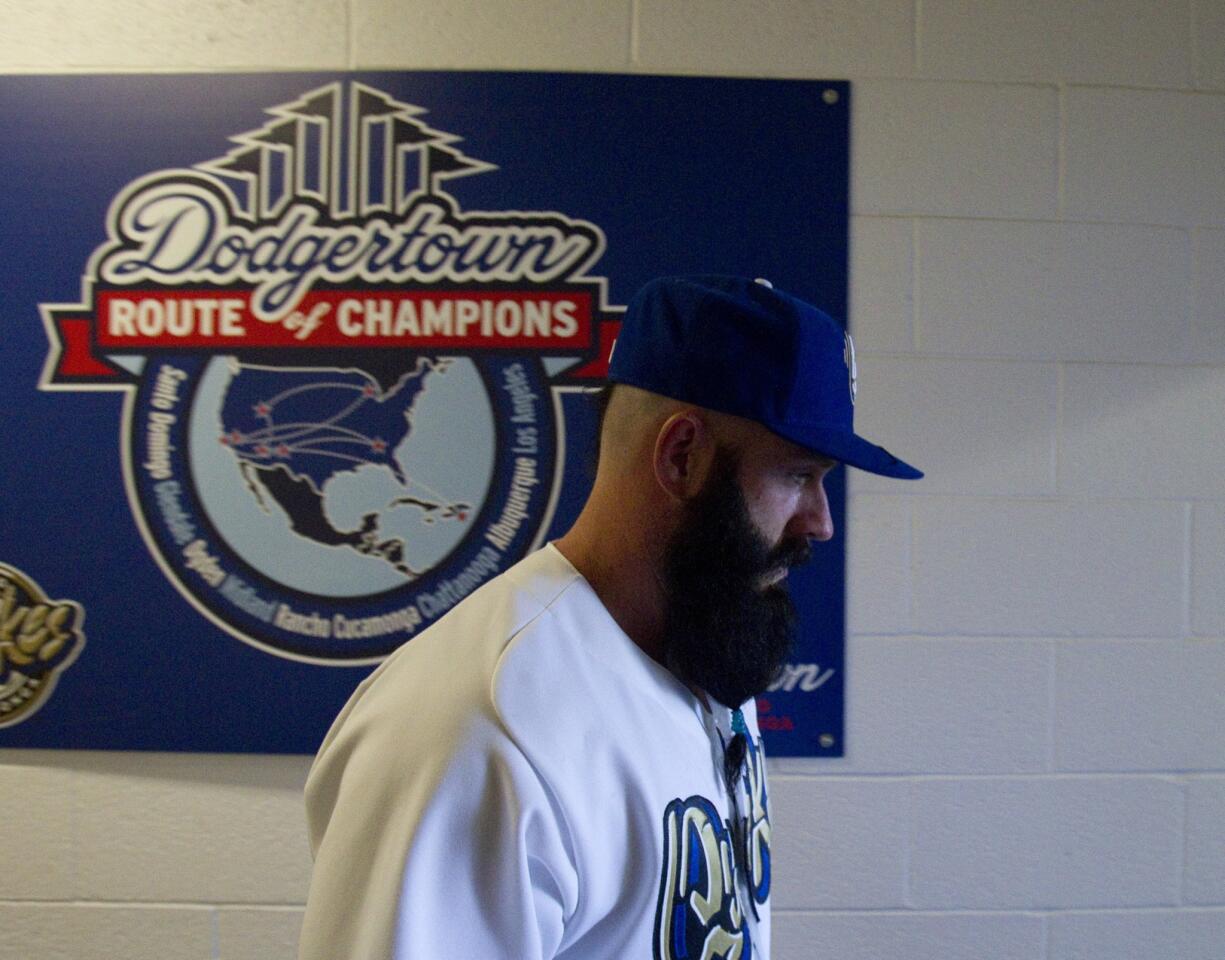 Newly signed relief pitcher Brian Wilson, who helped the San Francisco Giants win the 2010 World Series, walks down a hall toward the field before making his one-inning start in his Dodgers debut with the Rancho Cucamonga Quakes of the Class A California League on Wednesday.