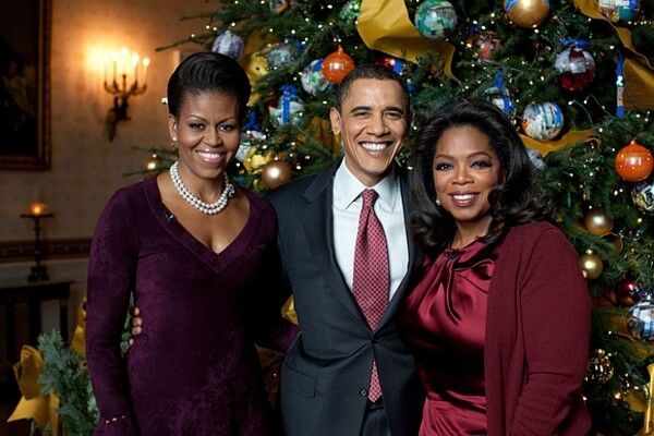 First Lady Michelle and President Barack Obama pose with Oprah Winfrey in the Blue Room of the White House during a taping of the ABC special, "Christmas at the White House." Michelle wore a purple velvet Azzedine Alaïa number.