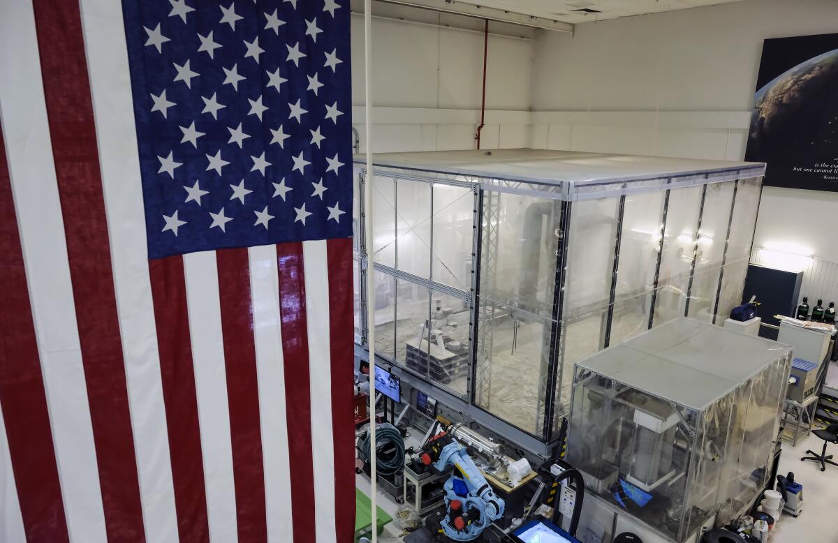 A flag hangs in the foreground with a large, dusty plastic bin in the background.