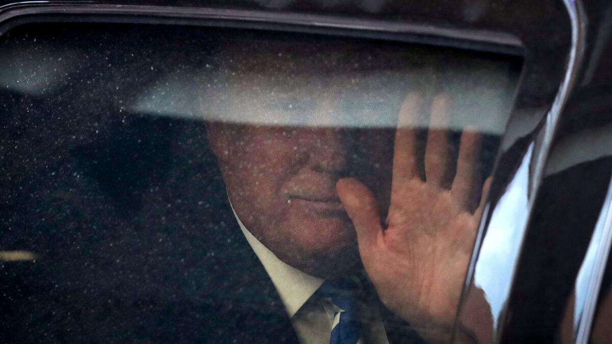 Donald Trump waved as he arrived at a Washington law office Thursday for a deposition in his lawsuit against celebrity chef Geoffrey Zakarian.