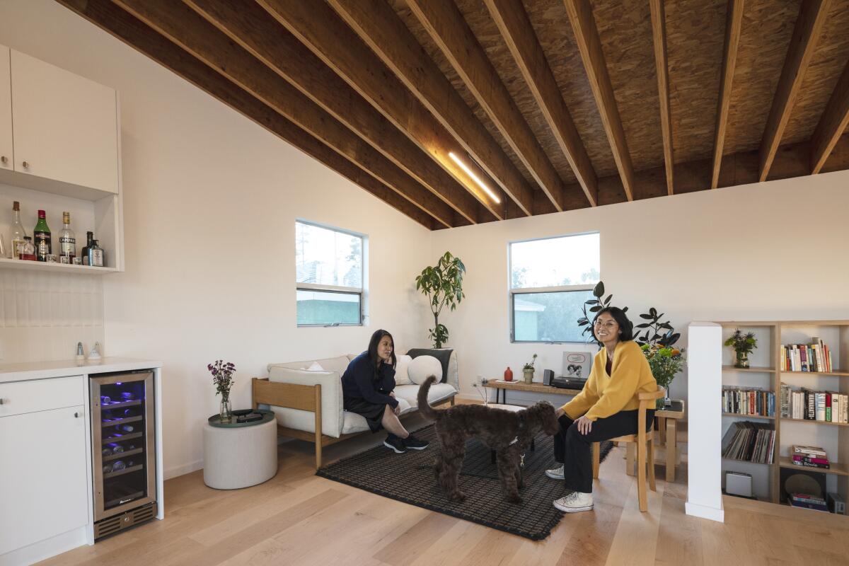 Two women sit in a living room.