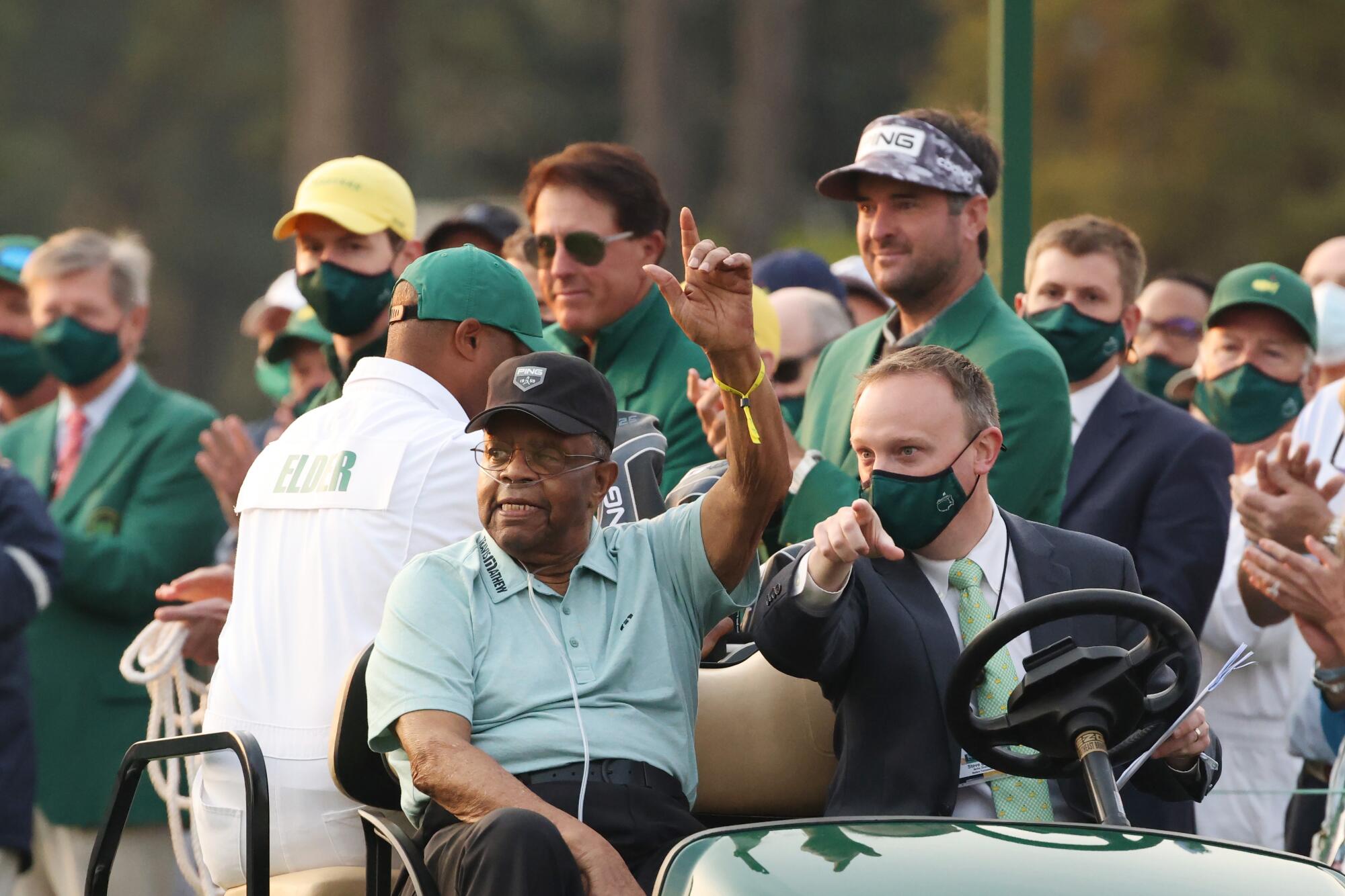 Honorary starter Lee Elder waves as he arrives to the opening ceremony during the first round.