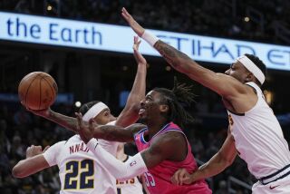 Delon Wright (55), de los Wizards de Washington, se enfrenta a Zeke Nnaji (22) y Bruce Brown (11), de los Nuggets de Denver, durante la primera mitad del juego de baloncesto de la NBA, el miércoles 22 de marzo de 2023, en Washington. (AP foto/Carolyn Kaster)