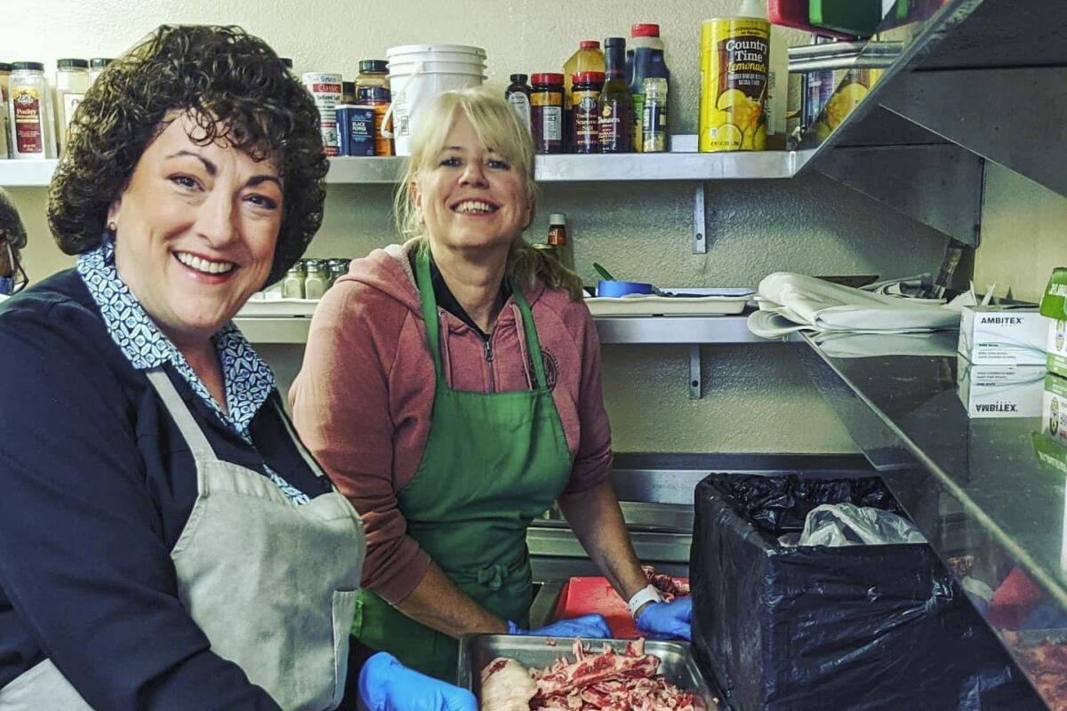 Two volunteers with the Long Beach Rescue Mission smile for the camera