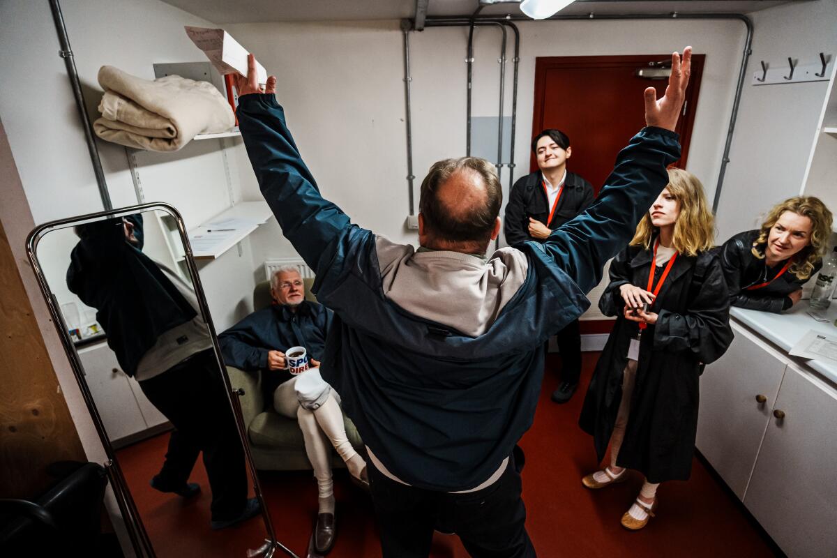 Viacheslav Yehorov, center, expresses himself to his cast members and gives them directorial notes in the dressing room.