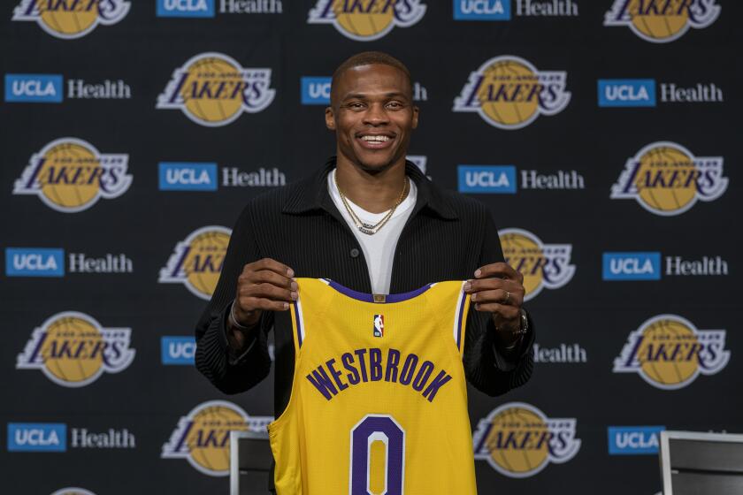 Los Angeles, CA - August 10: Russell Westbrook holds up his Lakers jersey after being introduced to the media as one of the newest Lakers by Vice President of Basketball Operations/General Manager Rob Pelinka and head coach Frank Vogel during a press conference at the Staples Center in Los Angeles Tuesday, Aug. 10, 2021. (Allen J. Schaben / Los Angeles Times)