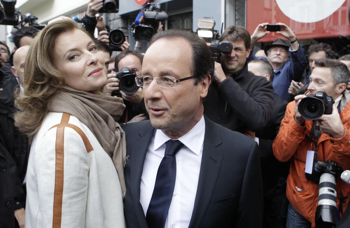 In 2012, presidential candidate Francois Hollande and companion Valerie Trierweiler leave after voting in Tulle, central France.