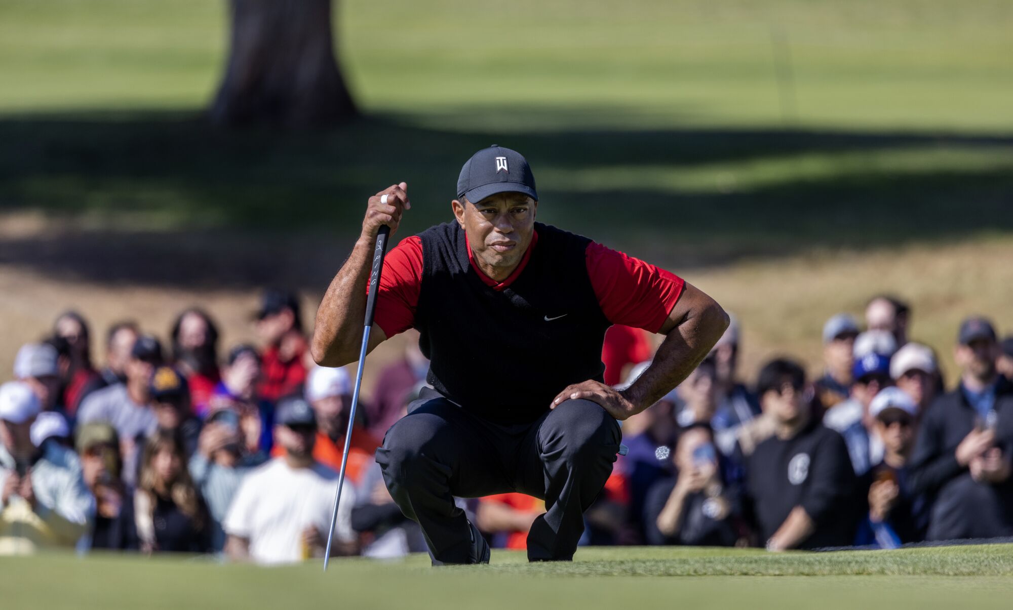 Tiger Woods lines up his putt on the ninth green in the final round.