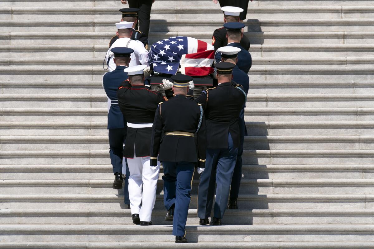 The flag-draped casket bearing the remains of Hershel W. "Woody" Williams is carried by joint service members into the U.S. Capitol, Thursday, July 14, 2022 in Washington, to lie in honor. Williams, the last remaining Medal of Honor recipient from World War II, died at age 98. (AP Photo/Jose Luis Magana)