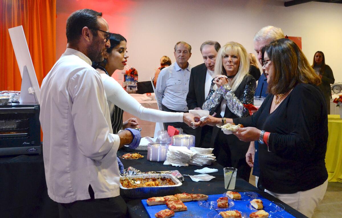 Giuseppe Accardi and Hajar serve Sicilian pizza and lasagna during the Balboa Island Museum Fun Zone Festival Friday night.