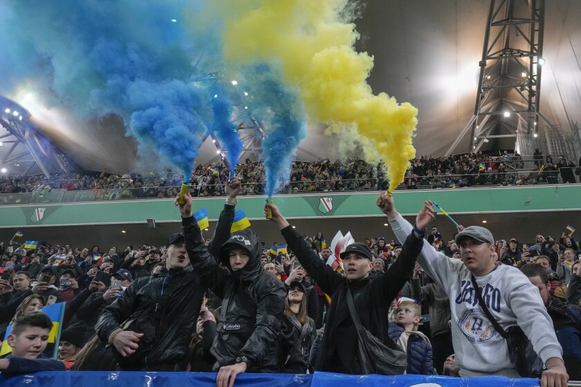 Spectators support Ukraine during a friendly charity soccer match between Legia Warszawa and Dynamo Kyiv in Poland.