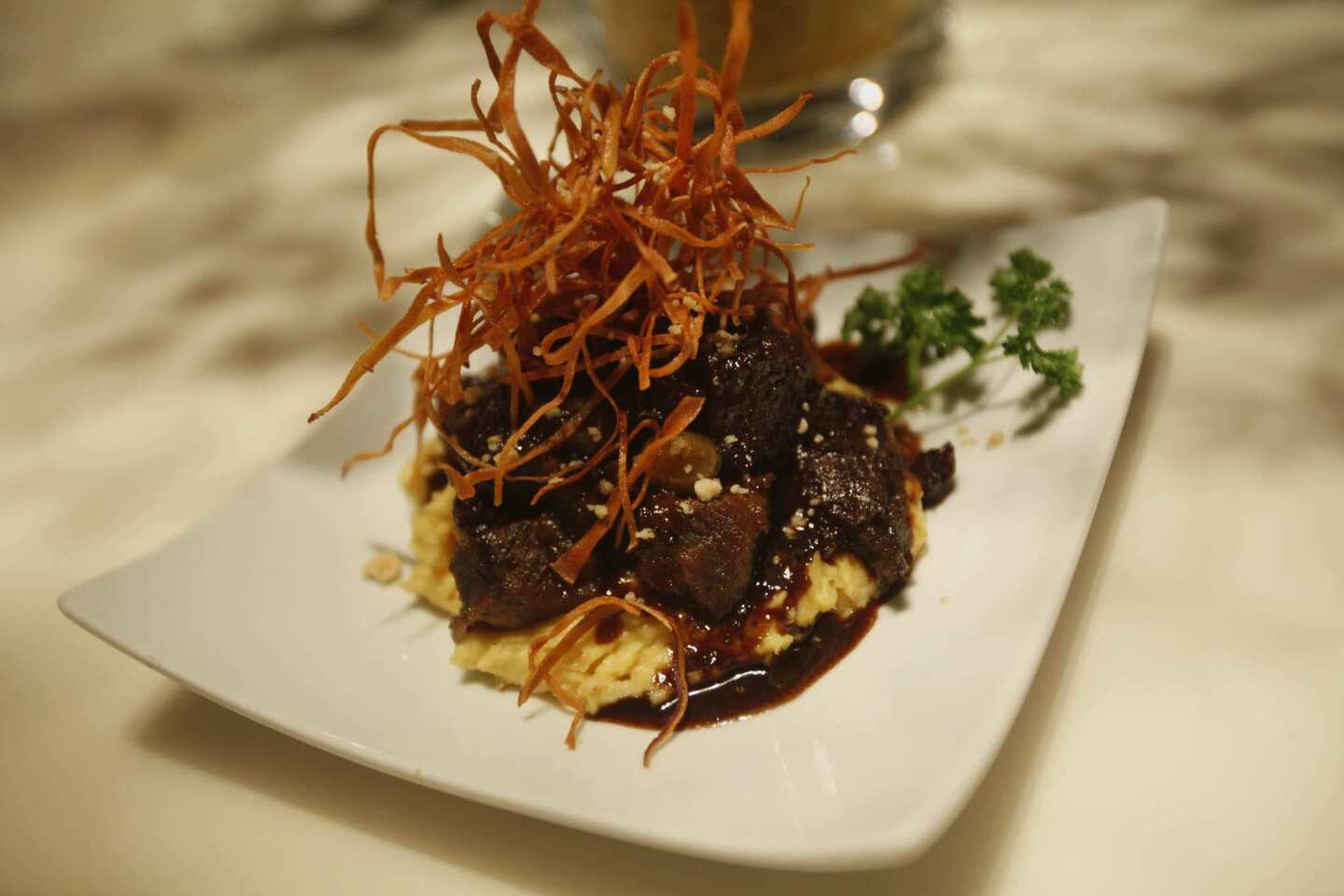 One of the most popular dishes is galbi jjim, braised short rib served atop mashed sweet potato and garnished with fried potato strips.