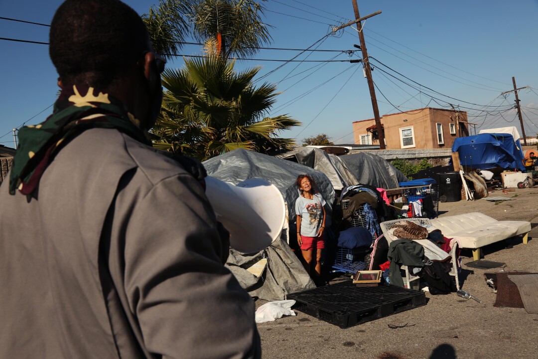 Gernay Quinnie Jr. tells Irma Peralta his crew will be feeding area homeless.