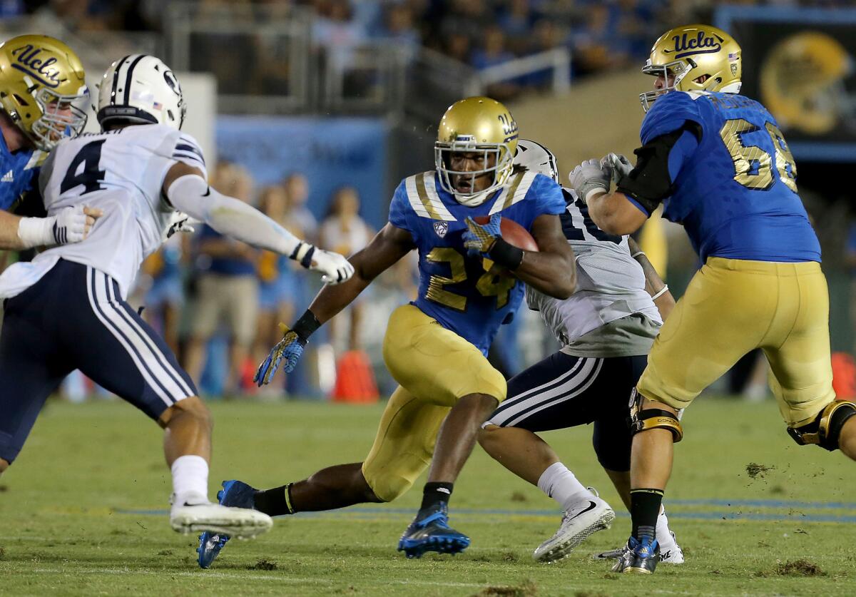 Bruins running back Paul Perkins breaks through the Cougars defensive front in the fourth quarter.